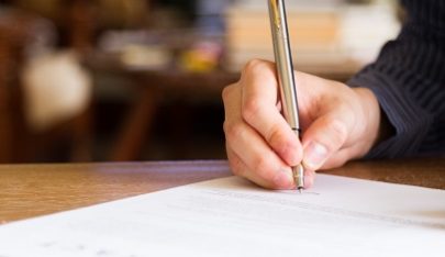 Person filling out form.