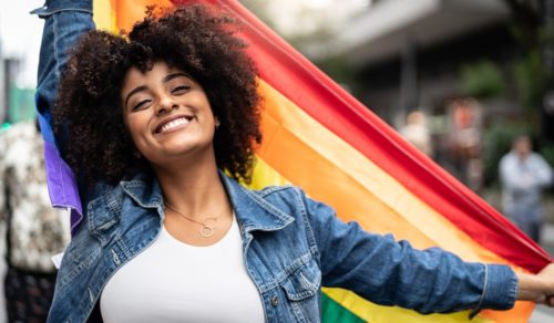 Woman Waving Rainbow Flag at Pride Parade
