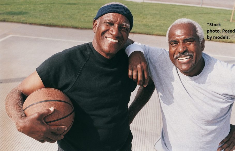 Two senior men on basketball court, holding a basketball