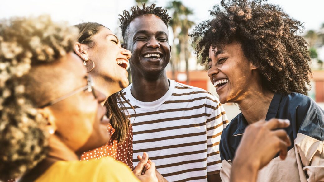 Young happy people laughing together – Multiracial friends group having fun on city street – Diverse culture students portrait celebrating outside – Friendship, community, youth, university concept