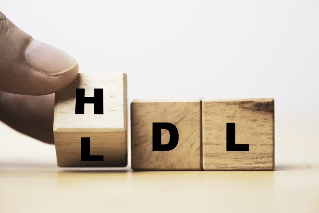 Hand flipping wooden cube block from change LDL to HDL for High is high density lipoprotein and LDL is low density lipoprotein concept.